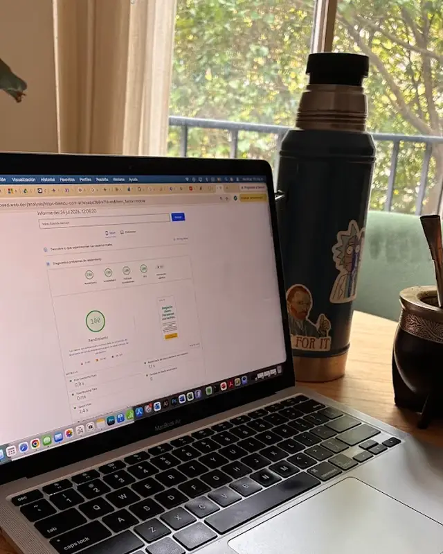 Notebook mostrando PageSpeed Insights con 100 en rendimiento, junto a un termo con mate